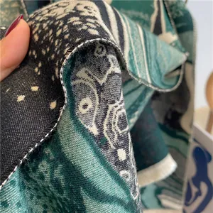 Macro di sciarpa jacquard verde scuro che mostra la trama intrecciata e le frange bianche