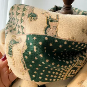 Detail of wool scarf featuring knitted horse patterns and forest green geometric accents