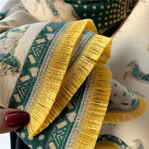 Detail of jacquard horse pattern wool scarf with dense yellow tassels and weave texture