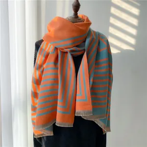 Détail d'une écharpe imitation cachemire avec rayures géométriques orange et bleues