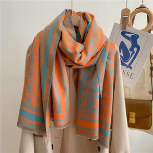 Detailed texture of thick star pattern scarf with fringes and orange-grey color block