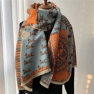 Detail of warm wool blend scarf with carriage print, orange and blue tassels