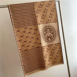 Detail of horse print scarf featuring classic greek meander medal and tassel edges