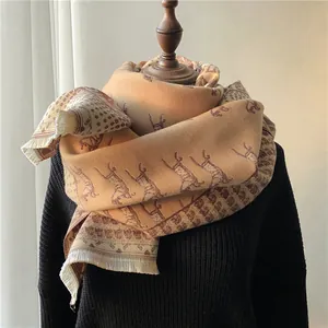Close-up of khaki wool shawl with vintage horse carriage patterns and tassel edges