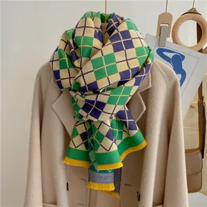 Détail d'écharpe à carreaux vert, marine et beige avec glands de franges jaunes