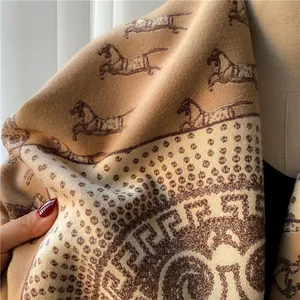 Close-up of thick camel wool blend scarf featuring equestrian horse patterns and geometric borders