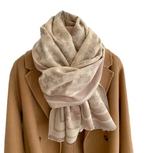 Winter faux cashmere scarf with star pattern and tassels on beige coat display