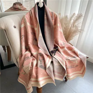 Detail of pink and beige cashmere-feel shawl featuring retro horse and tree patterns