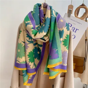 Détail du châle épais en cachemire à fleurs avec franges sur un manteau beige