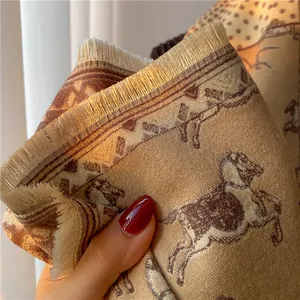 Detail of warm wool scarf featuring vintage horse print and gold fringe tassels