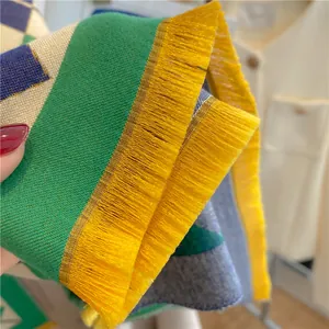 Vue détaillée de l'écharpe en maille multicolore avec de longues franges jaune vif au bord