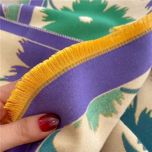 Détail d'une écharpe épaisse en cachemire avec motifs de tournesol et franges jaunes