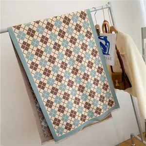 Détail d'une écharpe à carreaux bleu et marron avec franges sur un cintre
