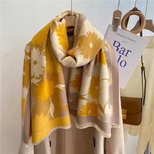 Détail du châle doux à motif tournesol avec franges sur un manteau en laine