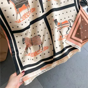 Detail of cashmere-like scarf showing luxury horse carriage pattern and soft fringes