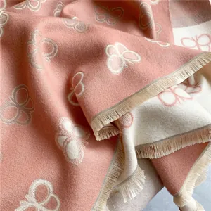 Detail of pink and beige cashmere-like scarf showing double-sided butterfly patterns