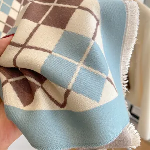 Gros plan de l'écharpe à carreaux bleu et marron montrant la texture et les franges