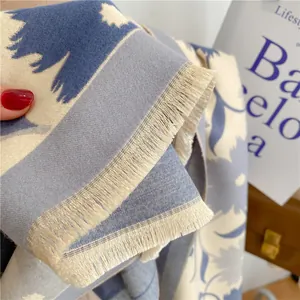 Détail d'un châle d'hiver épais bleu et blanc avec motif floral et bordures à franges