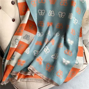 Detail of butterfly pattern thick scarf with Morandi blue and orange knit tassels