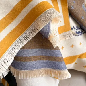 Detailed close-up of soft cashmere-like scarf with fringe edges and star pattern