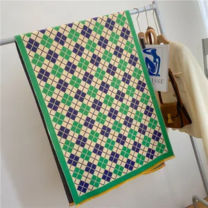 Écharpe en tricot à carreaux style britannique vert et bleu suspendue sur un cintre