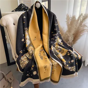 Detail of double-sided floral scarf with tassel edges on a beige sofa