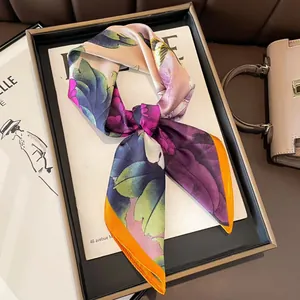 Elegant purple and green floral silk scarf with vibrant orange edges in a gift tray