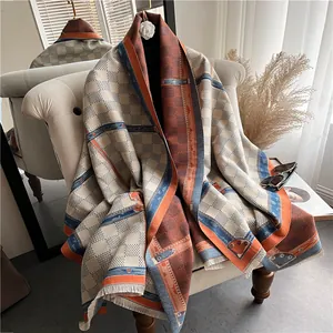 Dikke sjaal van imitatie-kasjmier met ruitpatroon, ruitprints en franjes op een fauteuil