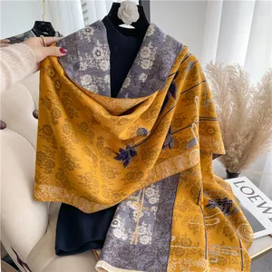 Detail of yellow and blue scarf featuring vintage floral patterns and fine fringe trim
