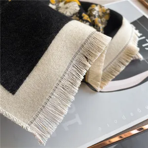 Detailed macro view of woven scarf fabric featuring soft long tassels and textured patterns