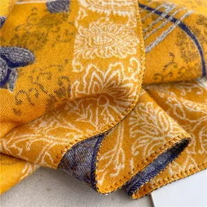 Close-up of yellow blue paisley pattern scarf showing the soft weave and neat edges