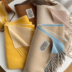 Bufandas suaves con flecos en varios colores con etiquetas de marca sobre mesa blanca