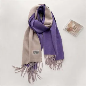 Detalle de la bufanda de cachemira reversible violeta y beige con flecos y etiqueta