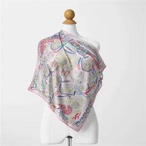 Detailed view of large silk scarf featuring classical harness and feather prints on pink