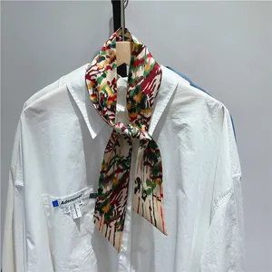 Detailed view of a retro French narrow silk scarf with abstract pattern on a shirt