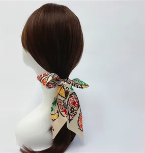 Detail of artistic paisley silk scarf tied as a ribbon on a low ponytail hairstyle
