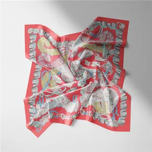 Close-up of coral red silk scarf featuring classic equestrian motifs and feather art patterns