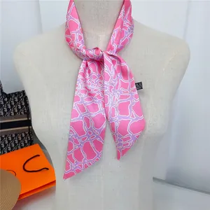 Detail of pink and purple silk twilly scarf with geometric patterns on white mannequin