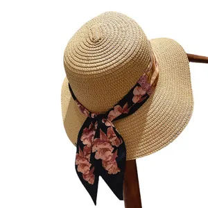 Elegant women's straw sun hat with black floral ribbon and bow for summer beach vacation