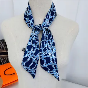 Elegant navy blue geometric print silk scarf tied on a white mannequin bust