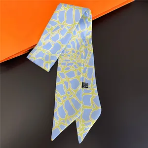 Detail of light blue silk scarf with yellow geometric patterns on orange background