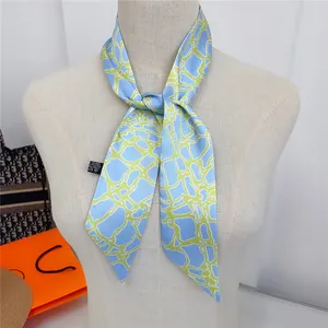 Detail showing the light blue satin scarf with neon grid pattern and polyester care label