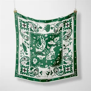 Detail of forest green and cream silk scarf featuring paisley and horse patterns