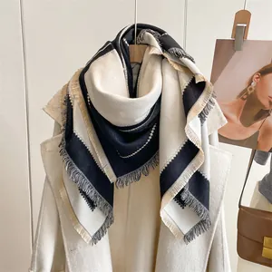 Détail d'une écharpe en imitation cachemire avec motifs géométriques et franges