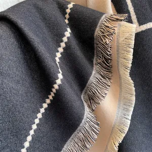 Détail d'un châle en imitation cachemire avec motifs géométriques et bordures à franges