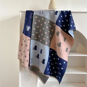 Detail of color-block scarf featuring cute cat silhouettes and polka dots with fringe