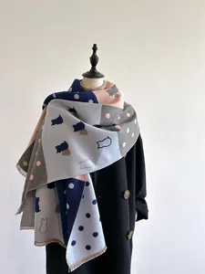 Detail shot of navy and pink cashmere scarf showing cat patterns and fringe edges