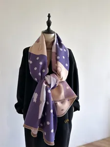 Detailed shot of cashmere scarf featuring purple color-block with white dots and cat motif