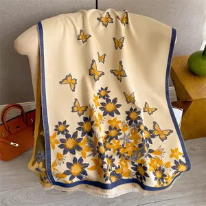 Close-up of butterfly floral printed shawl with delicate fringe on creamy fabric