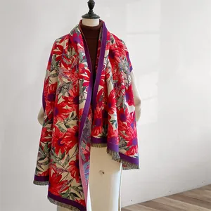 Close-up of vintage floral embroidery and fringe detail on ethnic winter shawl